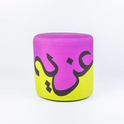 مقعد أوتومان مودرن بتصميم كلمة "عزيمة" بالخط العربي – ألوان حيوية (أرجواني وأخضر فسفوري) وتصميم فني مُلهم